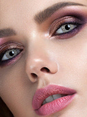 a close up of a child eating a pink donut